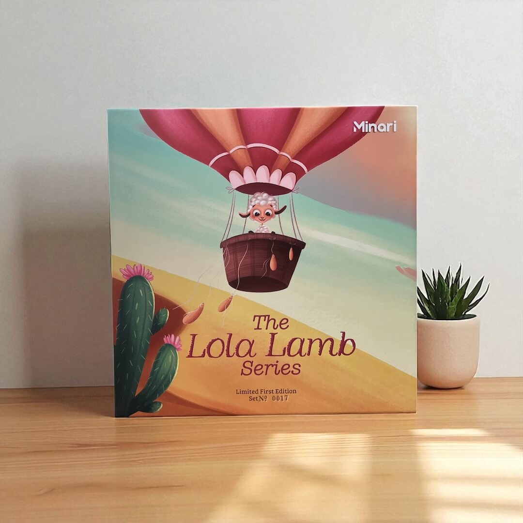 The Lola Lamb gift set on a wooden surface beside a small plant